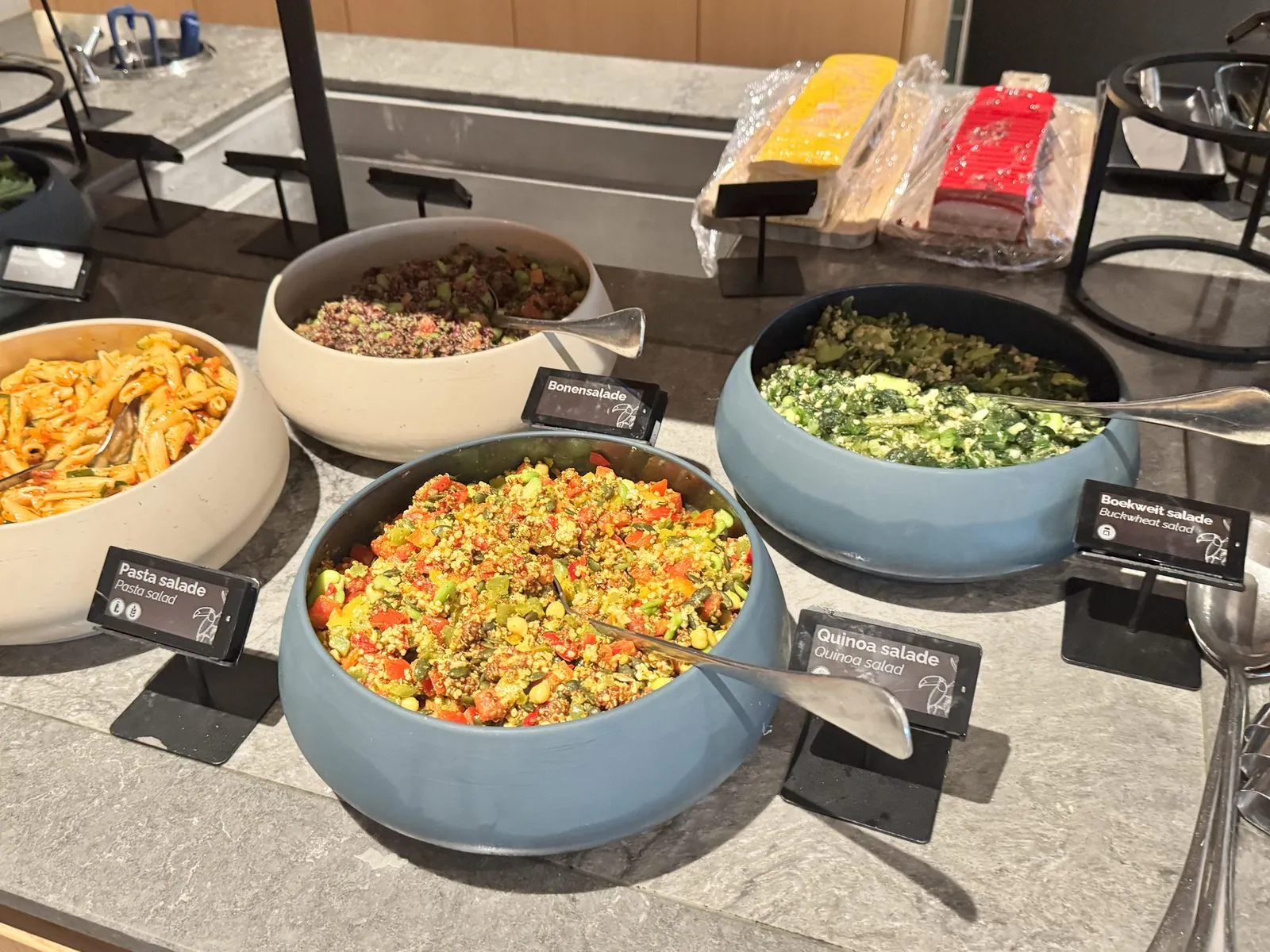 Meerdere Nomi e-labels bij salades op een hotelbuffet met allergeniconen