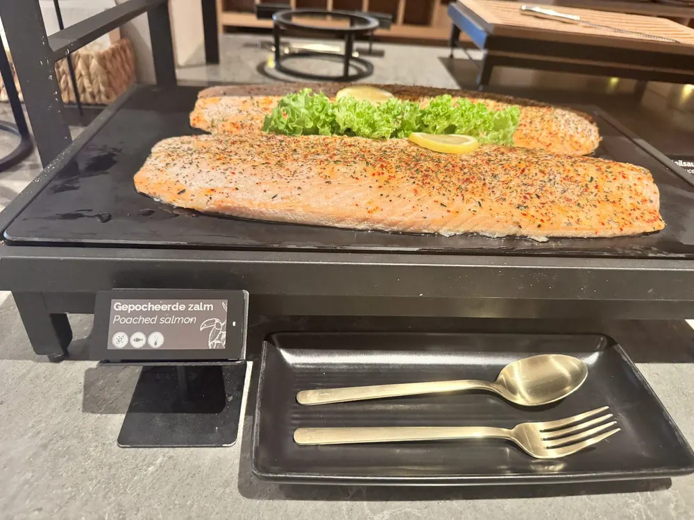 Nomi e-label bij gepocheerde zalm op een hotelbuffet