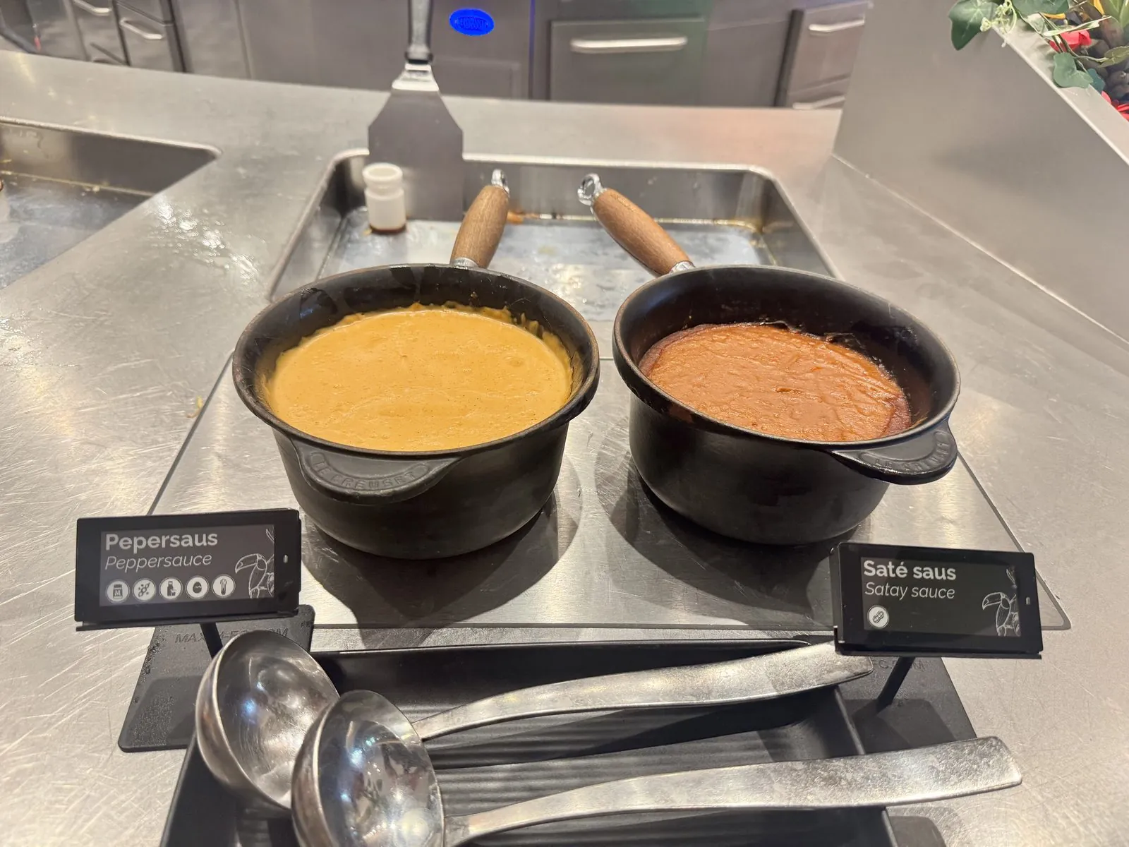 Nomi e-labels bij warme sauzen op een buffet