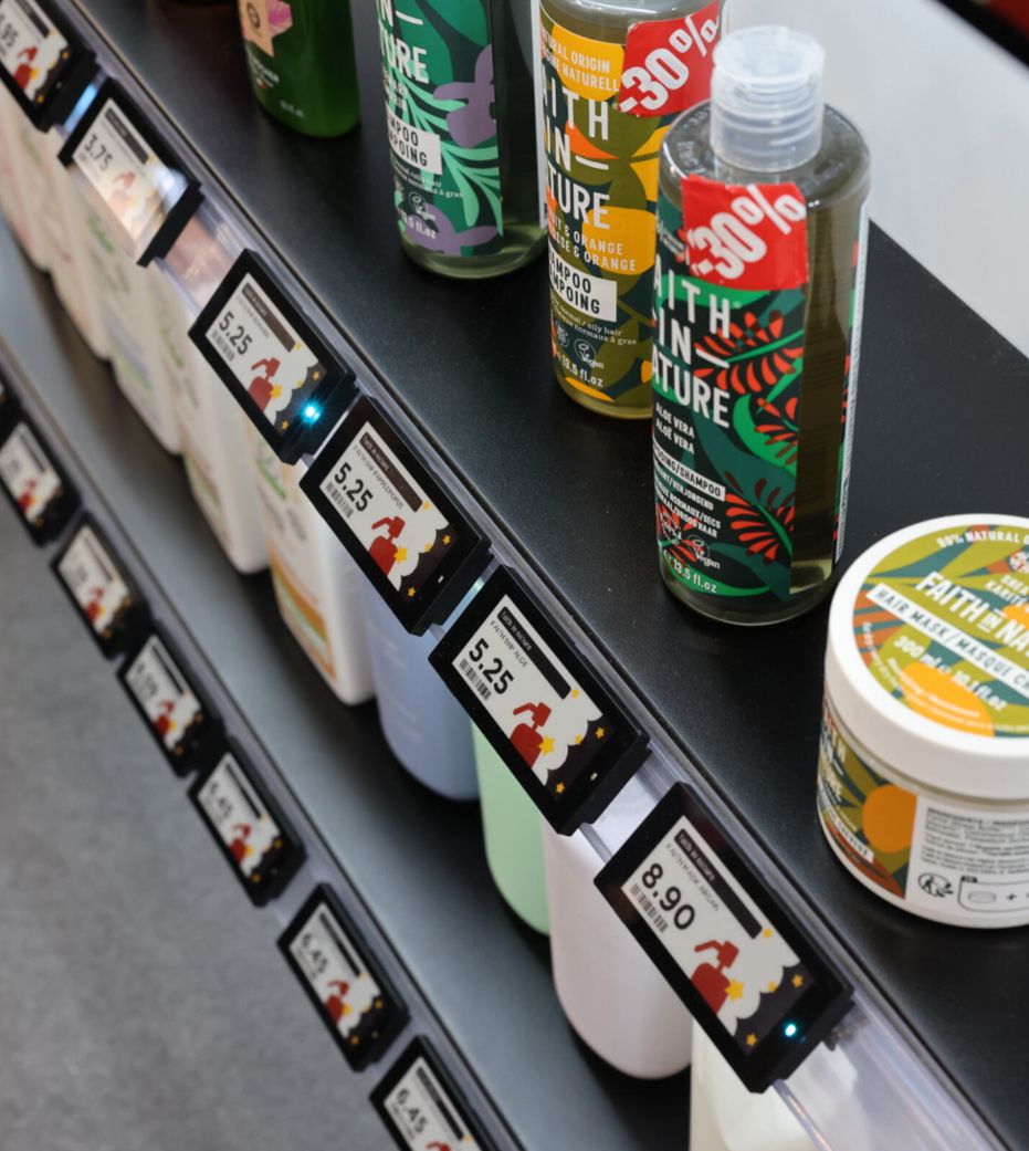 Hotel lobby shop met digitale Nomi prijslabels op planken
